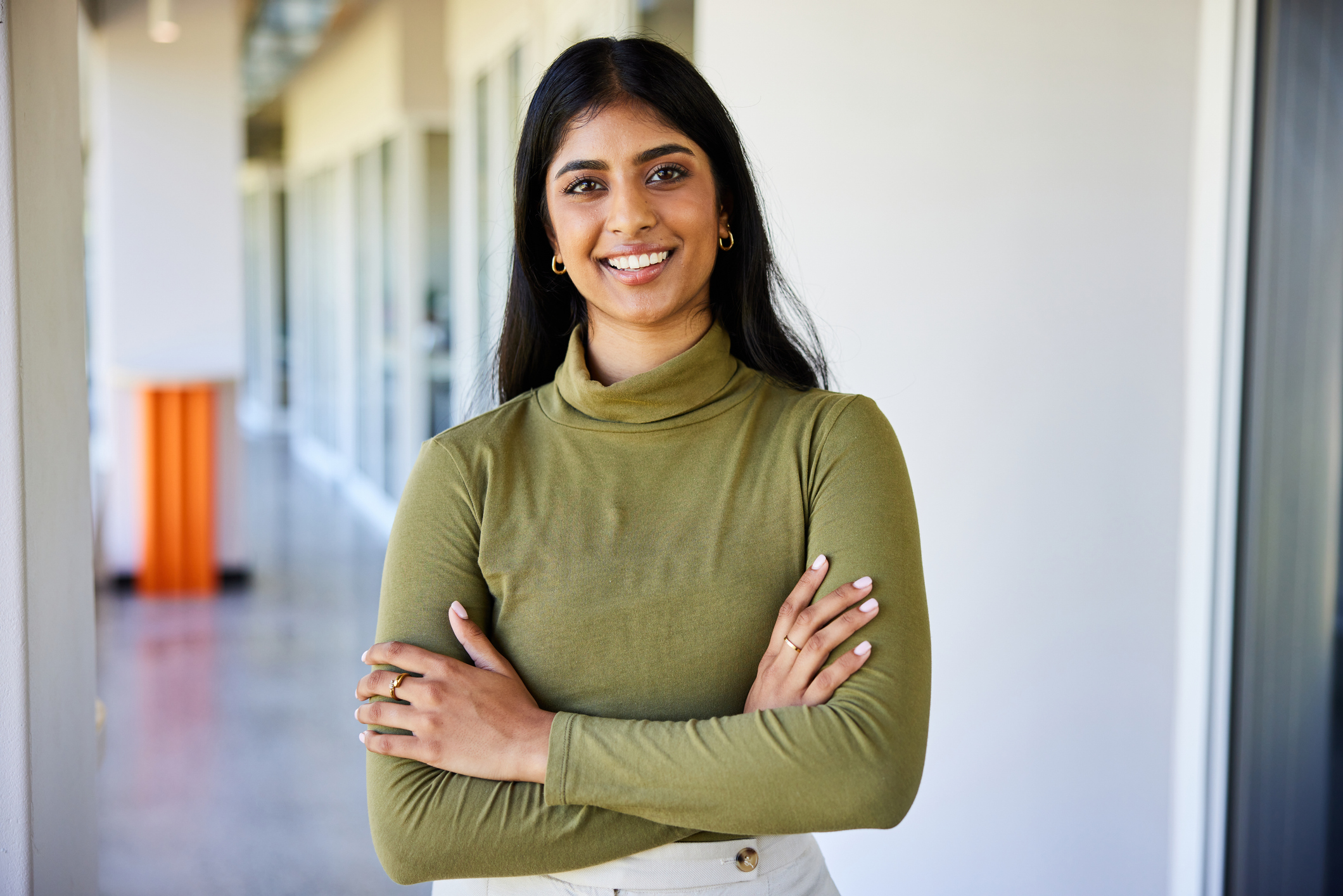 Smiling young businesswoman standing in the corridor of an office