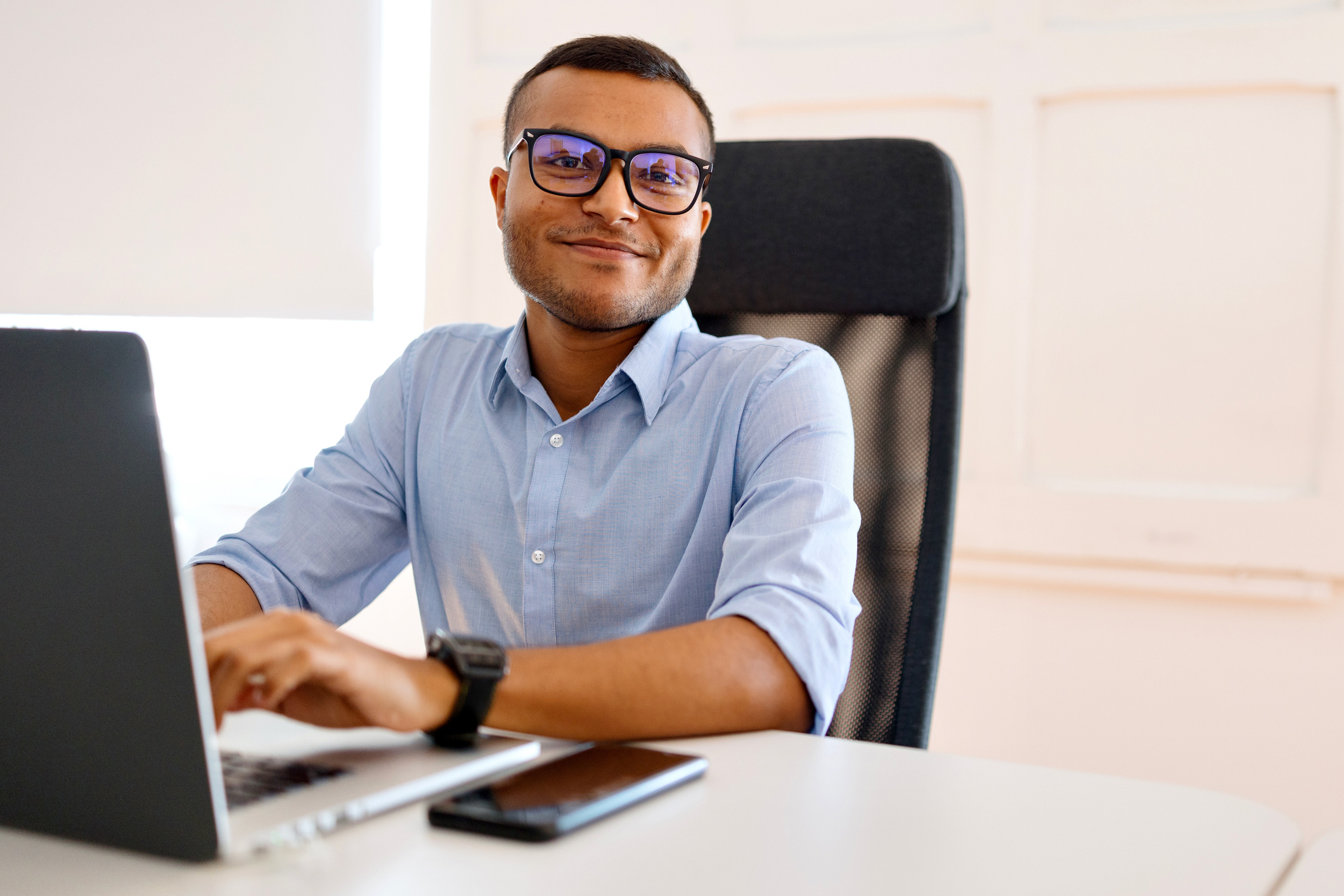 Portrait of a smiling multiracial businessman working on his laptop