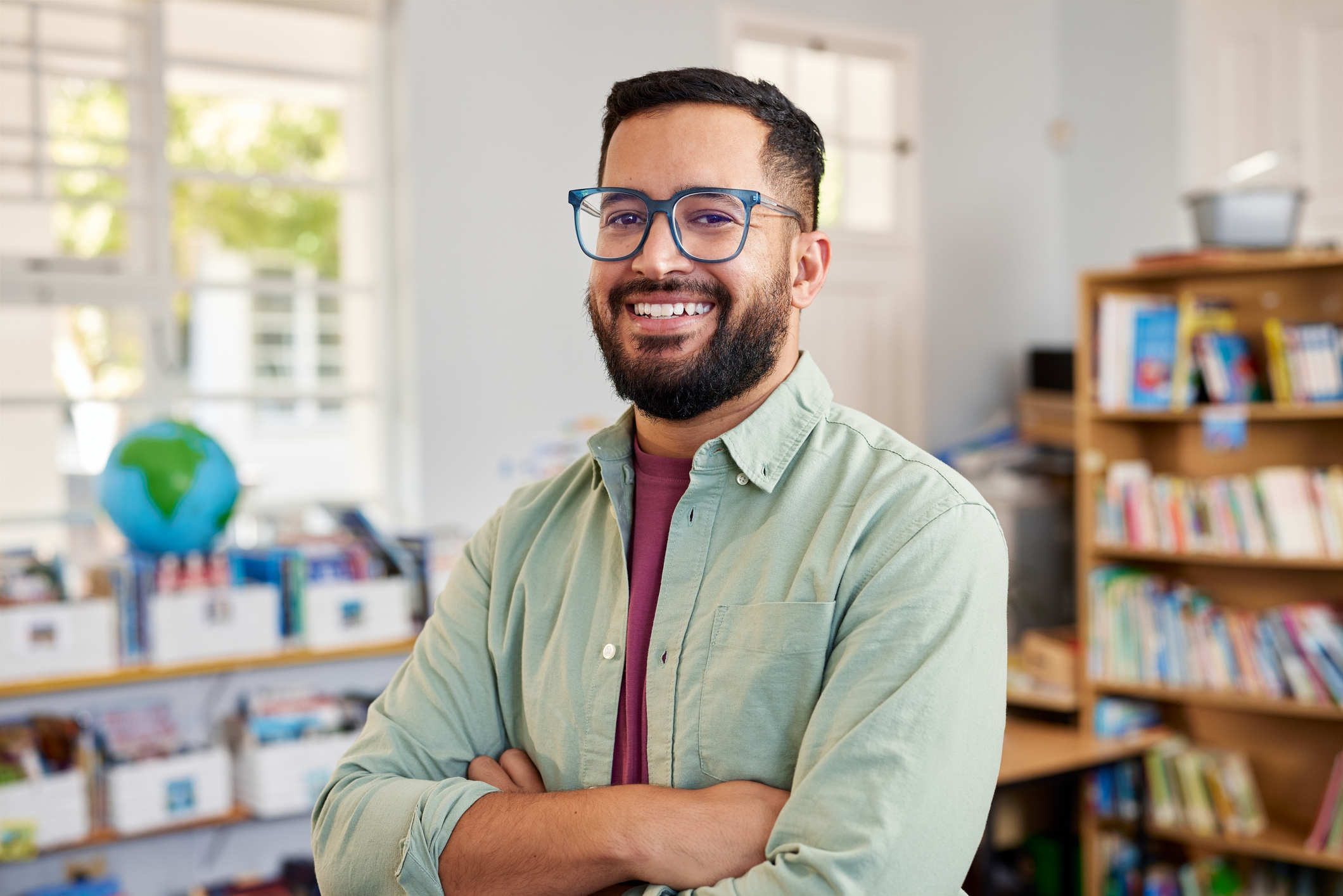 Happy multiethnic male teacher smiling at primary school